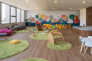 a childrens play room with green carpeting and circular chairs at Increible departamento en Punto Sur in Los Gavilanes