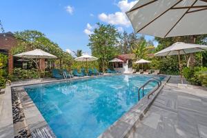 a swimming pool with chairs and umbrellas at Sweet Daisy Retreat in An Bàn (2)