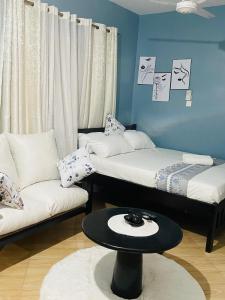 a room with two beds and a table and a couch at Kilifi Studio in Kilifi