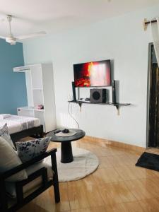 a living room with a tv on the wall at Kilifi Studio in Kilifi
