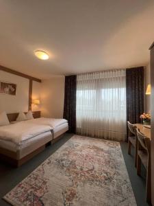 a bedroom with a bed and a table and a window at Zum Flößer in Neckartenzlingen