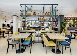 a restaurant with tables and chairs and shelves at Sercotel Madrid Aeropuerto in Madrid
