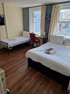 a bedroom with two beds and a desk with a chair at South Cliff Hotel in Blackpool