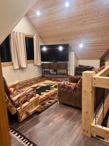 a living room with a large flat screen tv at Homer Spit View Cabins - The Log Cabin in Homer