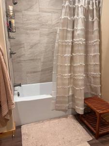 a bathroom with a bath tub with a shower curtain at Homer Spit View Cabins - The Log Cabin in Homer +24 photos