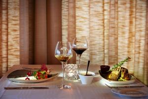 a table with two glasses of wine and food on it at Fosshotel Stykkisholmur in Stykkishólmur