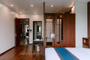 a hotel room with a bed and a desk and a mirror at Nova Hotel - 诺瓦酒店 in Yên Khê