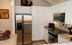 una cocina con nevera de acero inoxidable y armarios blancos en Snowcreek - 1503, en Sun Valley
