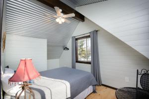 a bedroom with a bed and a ceiling fan at Homer Spit View Cabins - The Cottage in Homer
