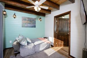a bedroom with a bed and a ceiling fan at Homer Spit View Cabins - The Cottage in Homer
