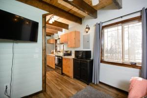 a kitchen with a tv on the wall at Homer Spit View Cabins - The Cottage in Homer