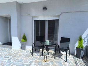 a patio with a table and two chairs in a room at Rael Apartments - free Parking in Katerini
