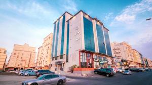 a large building with cars parked in a parking lot at منازل الضيف in Jeddah