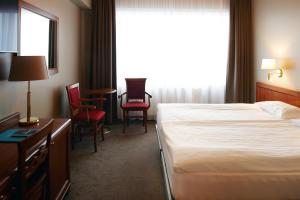 a hotel room with a bed and chairs and a window at Fosshotel Stykkisholmur in Stykkishólmur