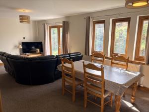 a living room with a table and a couch at Abernethys Cottage in Connel