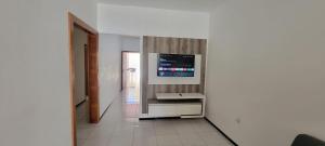 a living room with a television on a wall at Casa de praia em Guriri in Guriri