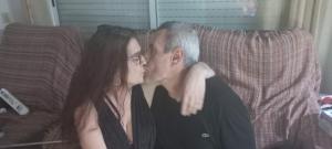 a man and a woman sitting on a couch kissing at Jose María in El Vendrell