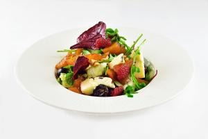 a white plate with a salad with strawberries and greens at Harvey Spa Hotel in Františkovy Lázně