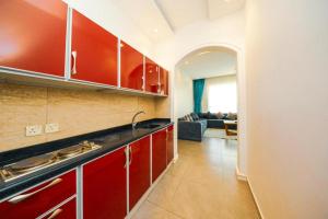 a kitchen with red cabinets and a living room at منازل الضيف in Jeddah