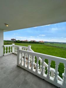 a white balcony with a view of a green field at Sol Dorado in Ferrero