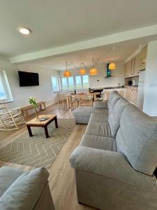 a living room with a large couch and a kitchen at Sol Dorado in Ferrero