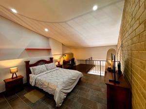 a bedroom with a bed and two lamps and a wall at Apartamentos Chia in Chía