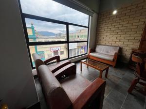 a living room with a couch and a chair and a window at Apartamentos Chia in Chía