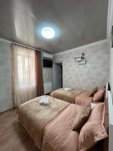 a bedroom with two beds and a large window at garden and panorama in Mtskheta