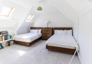two beds in a room with white walls and windows at The Townhouse in Cahersiveen
