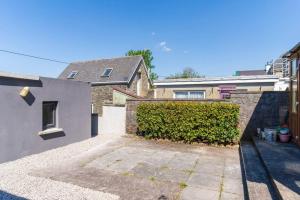 a house with a hedge next to a building at The Townhouse in Cahersiveen