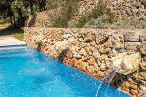 a stone retaining wall with two water fountains at Finca Ses Curtanetas by 3VILLAS in Alaior +36 photos