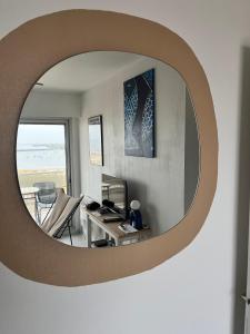 a living room with a circular mirror on the wall at Appartement front de mer - Terrasse in Pornichet +19 photos