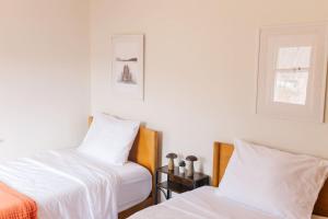 a room with two beds with white sheets and a window at Lakefront Retreat Home- Swimming-Fishing-Boating in Bethlehem