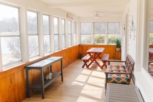 a room with windows and a table and chairs at Lakefront Retreat Home- Swimming-Fishing-Boating in Bethlehem