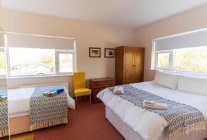 a bedroom with a large bed and a yellow chair at Tri Phailme in Waterville