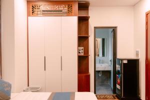 a bedroom with a large white cabinet and a mirror at Nova Hotel - 诺瓦酒店 in Yên Khê