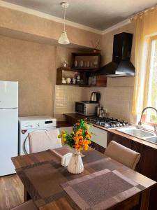 a kitchen with a table with a vase of flowers on it at garden and panorama in Mtskheta