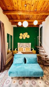 a bedroom with a large bed with a green wall at Duomo Charming Rooms in Barletta