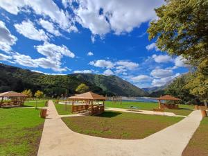 a park with benches and gazebos and a lake at Apartment Relax in Plužine +38 photos