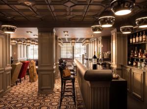 eine Bar mit Theke und einigen Flaschen Wein in der Unterkunft Hotel le Cinq Hyper - Centre in Chambéry