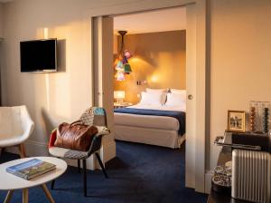 ein Hotelzimmer mit einem Bett und einem Stuhl in der Unterkunft Hotel le Cinq Hyper - Centre in Chambéry
