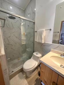 a bathroom with a shower and a toilet and a sink at Villa Paradise in Jacó