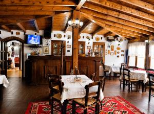 a dining room with a table and a tv at Guva Mangalem Boutique Hotel & Restaurant -Berat Old Town View in Berat