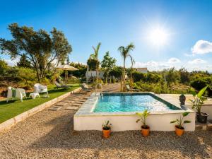 a swimming pool in a yard with chairs and trees at Casa Oliveira in Silves