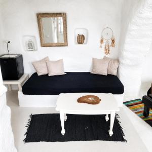 a bedroom with a bed and a table with a hat on it at Artemis Cottage Authentic Mykonian Stone House near Super Paradise in Super Paradise Beach