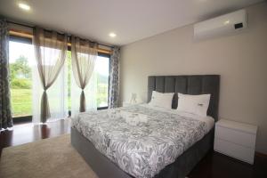 a bedroom with a large bed and a large window at Villa Travessa das Lages in Vieira do Minho +69 photos