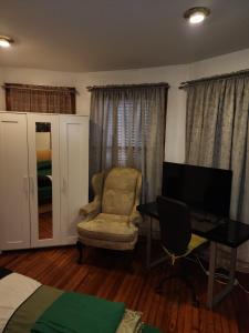 a living room with a chair and a desk and a television at Sensational in Elizabeth