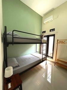 two bunk beds in a room with a window at Secretspot Yogyakarta in Yogyakarta