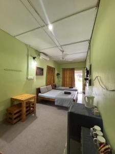 a bedroom with a bed and a table in a room at Studio Khalida Taman Perdana in Pekan