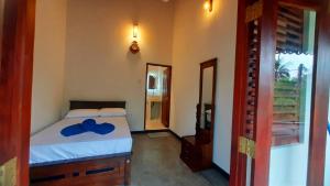 a bedroom with a bed with a blue bow on it at Anchor House in Ahangama